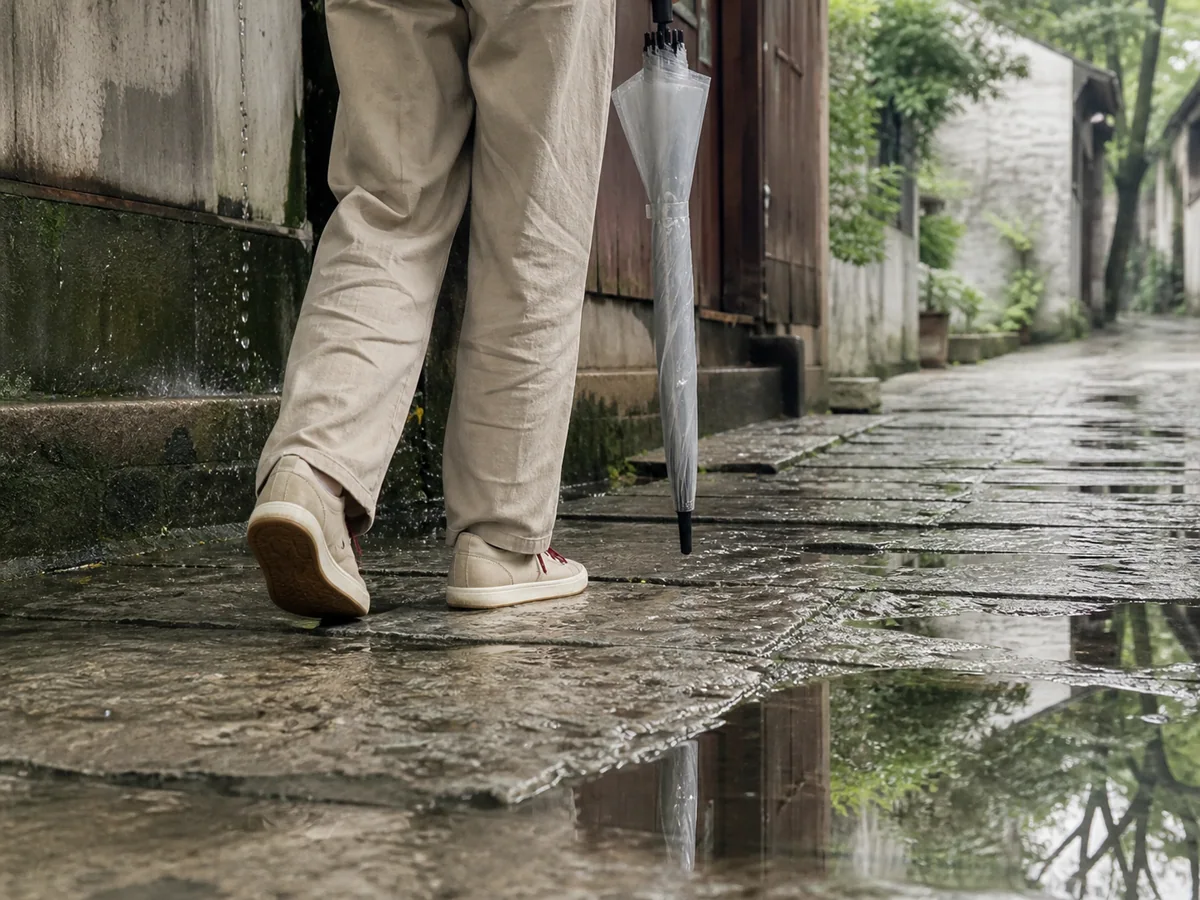 雨后撑着收起的伞稳稳走过石板路